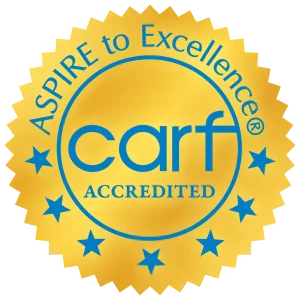Gold seal with blue stars and text, "CARF Accredited, Aspire to Excellence.
