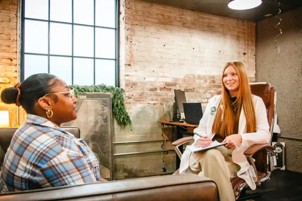 A doctor in a white coat consults with a patient in an office setting.