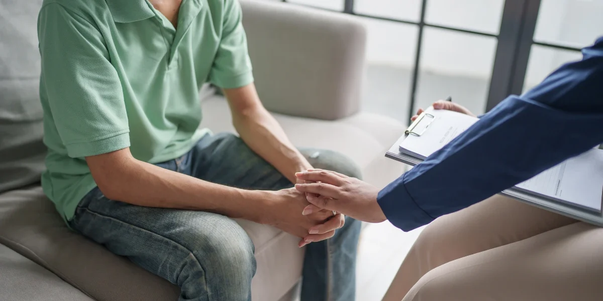 Mental health therapist offering reassurance and support to an adolescent during a counseling session, representing compassionate treatment for teen anxiety, depression, and emotional challenges.